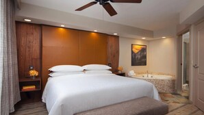 A hotel room with a large bed, a ceiling fan, a bathtub, and a painting on the wall. - Large 1-Bdrm Villa in lovely Avon, CO- available wk of July 22-29 (Avon)