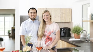 Una cocina moderna con una isla central, una cafetera y una planta en maceta.