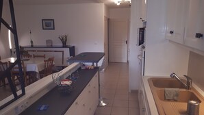 Una cucina moderna con isola centrale, lavello e zona pranzo con sedie e tavolo.