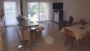 Una cucina moderna con zona pranzo, divano e televisione.