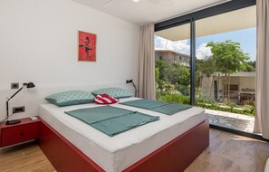 A modern bedroom with a large bed, a nightstand, a lamp, and a poster on the wall. - Beach front home in Palit with sauna (Palit)