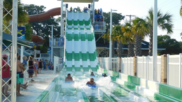 Parque acuático con varias toboganes y una zona de piscina.