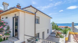Ein weißes Gebäude mit Balkon und Meerblick.
