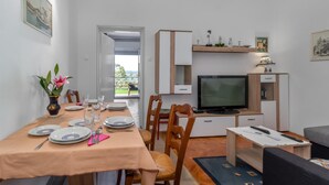 Un espacio habitable compacto con comedor, televisión y una pequeña zona de estar.