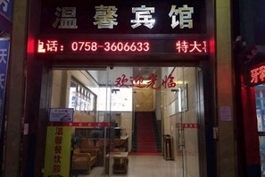 A hotel entrance with a glass door, a staircase, and a sign indicating a special rate. - Wenxin Hotel (Sihui)