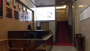 A hotel lobby with wooden furniture, a reception desk, and a staircase. - Wenxin Hotel (Sihui)