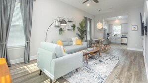 Un salon moderne avec un canapé gris, une table basse et un ventilateur de plafond.