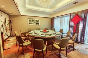 A conference room with a round table, chairs, and a chandelier. - Baoqing Villa (Shaoyang)