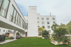 Un edificio moderno con techo plano, amplias ventanas y un césped cuidado.
