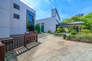 Un patio con un edificio, una cerca de madera y un área de estar techada.