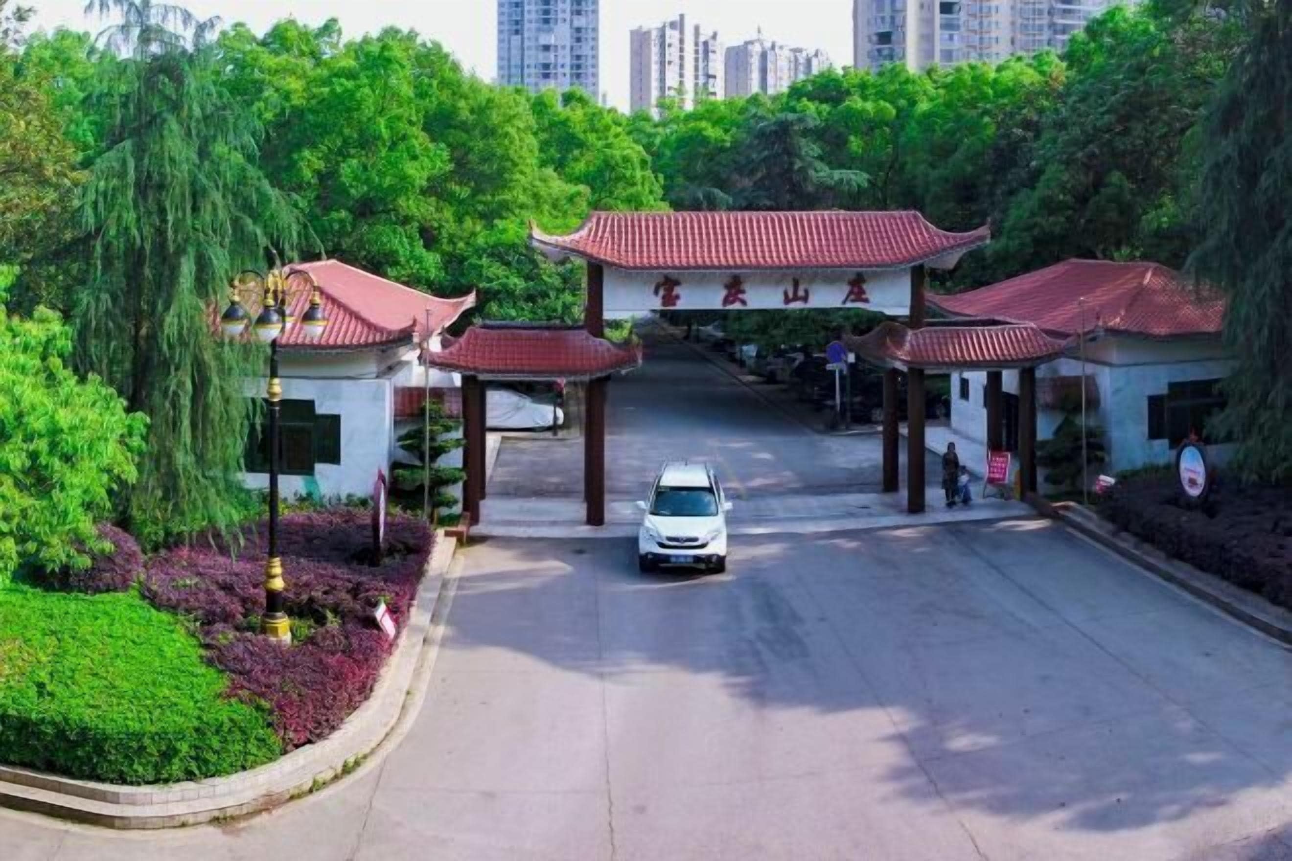 A traditional Chinese gate with a white car parked in front.
