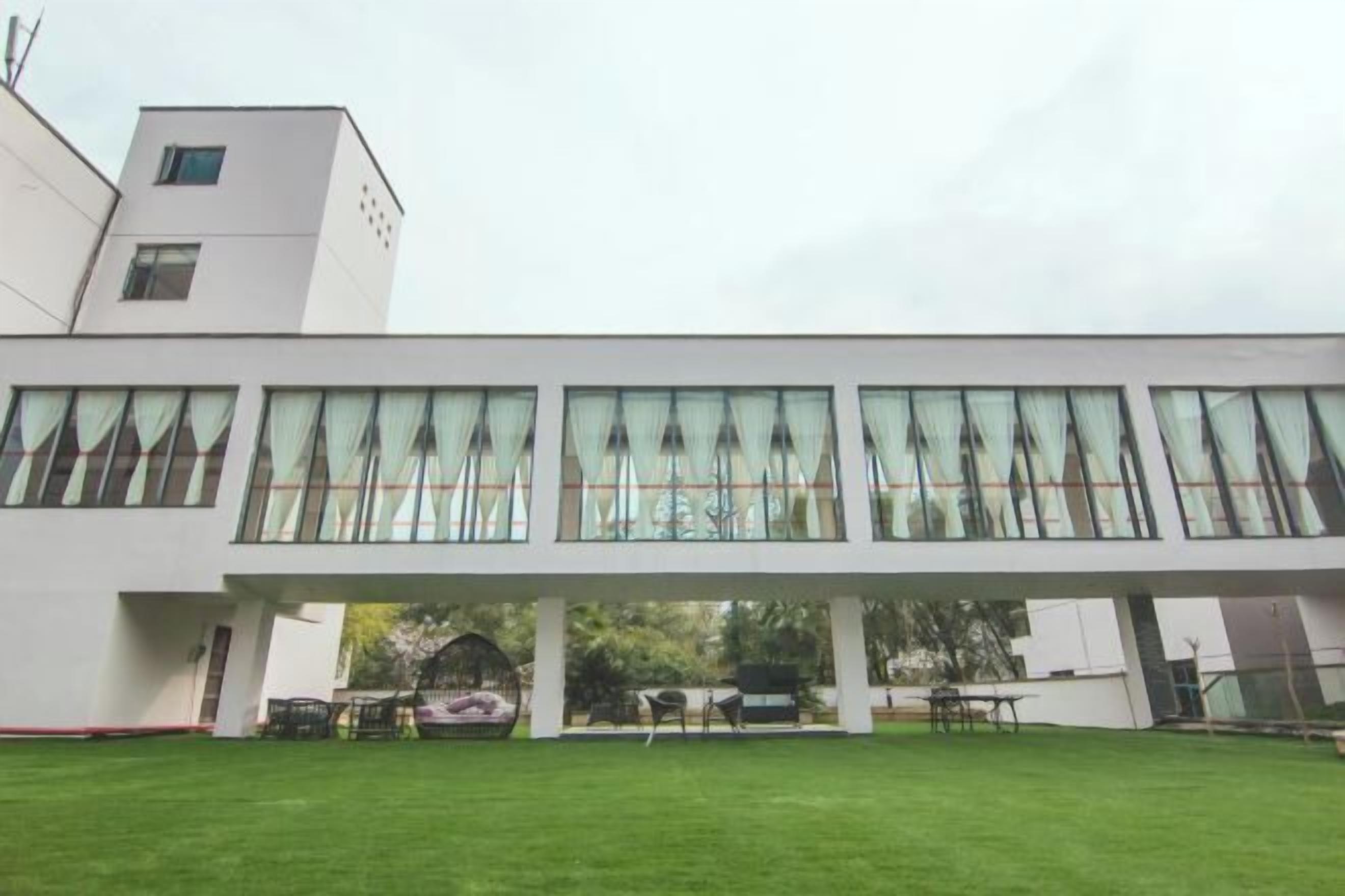 A modern building with large windows and a covered outdoor seating area.
