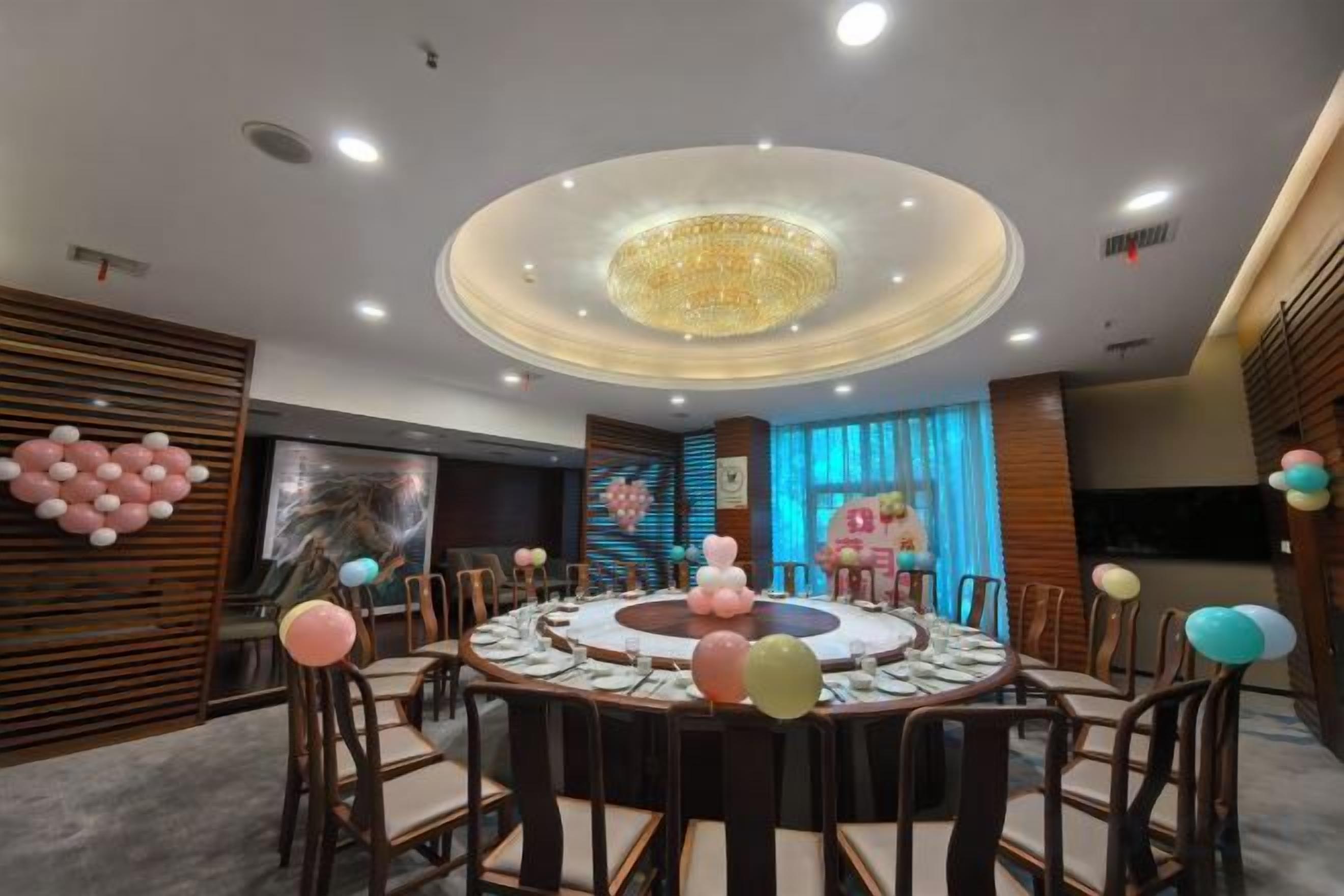 Un salón de conferencias con una mesa redonda, sillas y una lámpara de araña.