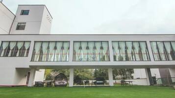 A modern building with a flat roof, large windows, and a covered walkway.