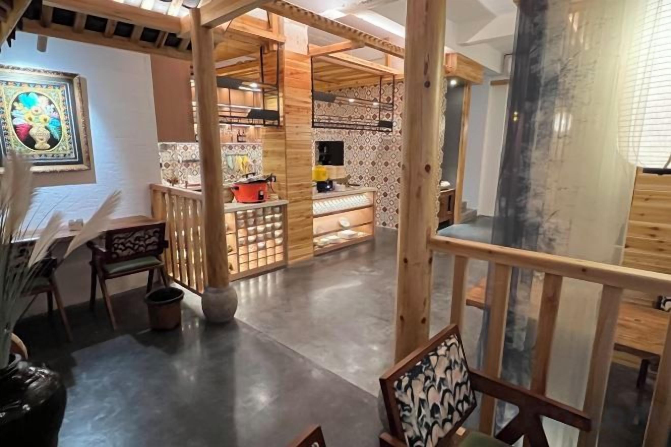 Un espacio amplio con zona de cocina, muebles de madera y vistas al exterior.