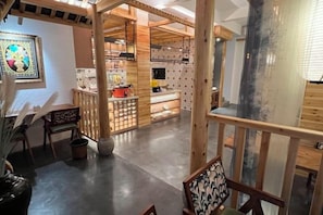 A spacious interior with a kitchen area, wooden furniture, and a view of the outside. - Yixunli Theme Hotel (Luoping)