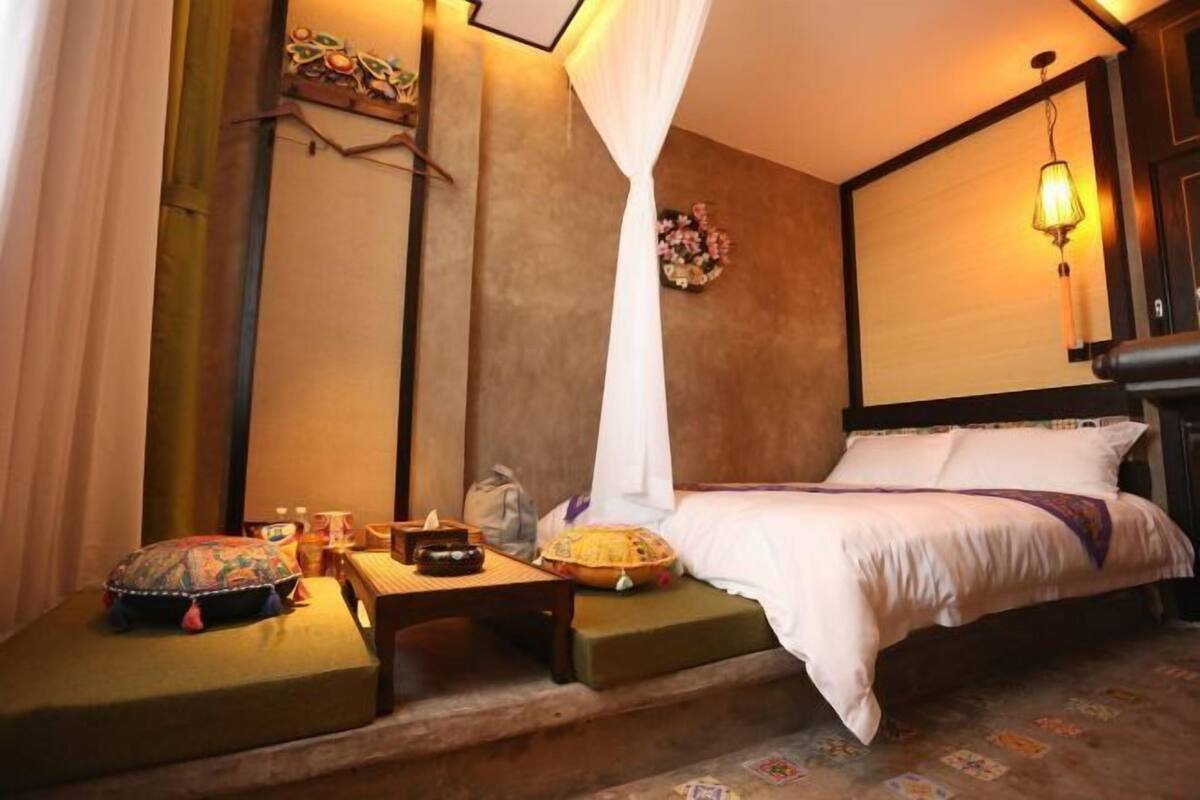 Ein Zimmer mit Bett, Nachttisch, Lampe und Dekoration.