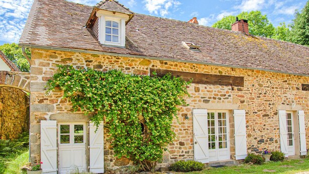 A stone building with a tiled roof, white shutters, and a vine-covered wall. - Cozy home in Janailhac with outdoor swimming pool (Janailhac)