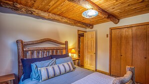 A wooden-framed bed with a headboard, a bedside table, and a nightstand.