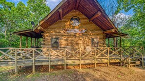 A rustic wooden cabin with a triangular roof, a front porch, and a sign reading "Big Buffalo."
