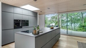 A modern kitchen with a large island, built-in appliances, and a view of the outdoors. - Gorgeous home in Bryrup with kitchen (Bryrup)