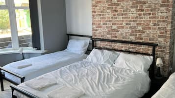 2 habitaciones, escritorio y tabla de planchar con plancha
