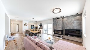 A spacious living area with a large sofa, a fireplace, and a dining area with a kitchen in the background. - Beautiful home in Trogir (Trogir)