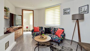Un salon moderne avec un canapé, une table basse et un lampadaire.