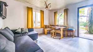 A modern living room with a sofa, a dining table with chairs, and large windows with curtains. - Awesome home in Kamionki Male (Kamionki Male)