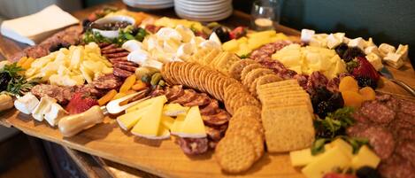 Une planche de charcuterie avec divers fromages, viandes et fruits.