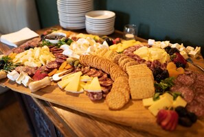 A charcuterie board with various cheeses, meats, and fruits.