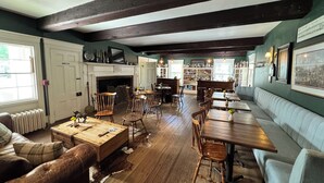 A room with a fireplace, wooden furniture, a bar area, and a seating area. - OneSixtyFive (Brunswick)