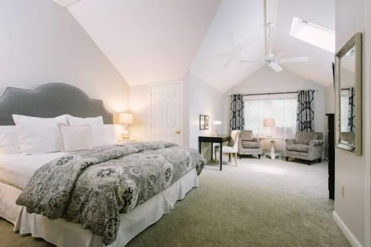 A bedroom with a bed, a desk, and a chair.