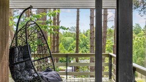 A wooden deck with a hanging chair and a view of a forest. - Awesome home in Ebeltoft with WiFi (Ebeltoft)