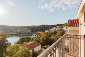 Un pueblo costero con edificios que dan a una masa de agua, con balcones y barandillas de hierro forjado.