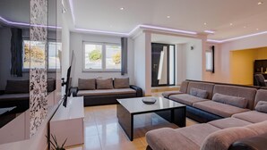 Ein modernes Wohnzimmer mit einer Couch, einem Couchtisch und einem Fernseher.