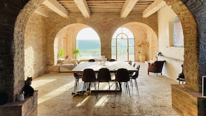 A rustic dining area with a high wooden ceiling, stone arches, and a large table with chairs. - Beautifully restored Tuscan villa, with private pool and breathtaking views (Monteroni d'Arbia)