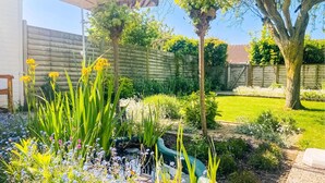A garden with a pond, various plants, and a wooden fence. - 2 bedroom awesome home in Bredene (Bredene)
