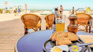 Ein Tisch mit einer Flasche Blanche de Narmer Bier, Brotscheiben, Butter und einer Pfeffermühle.
