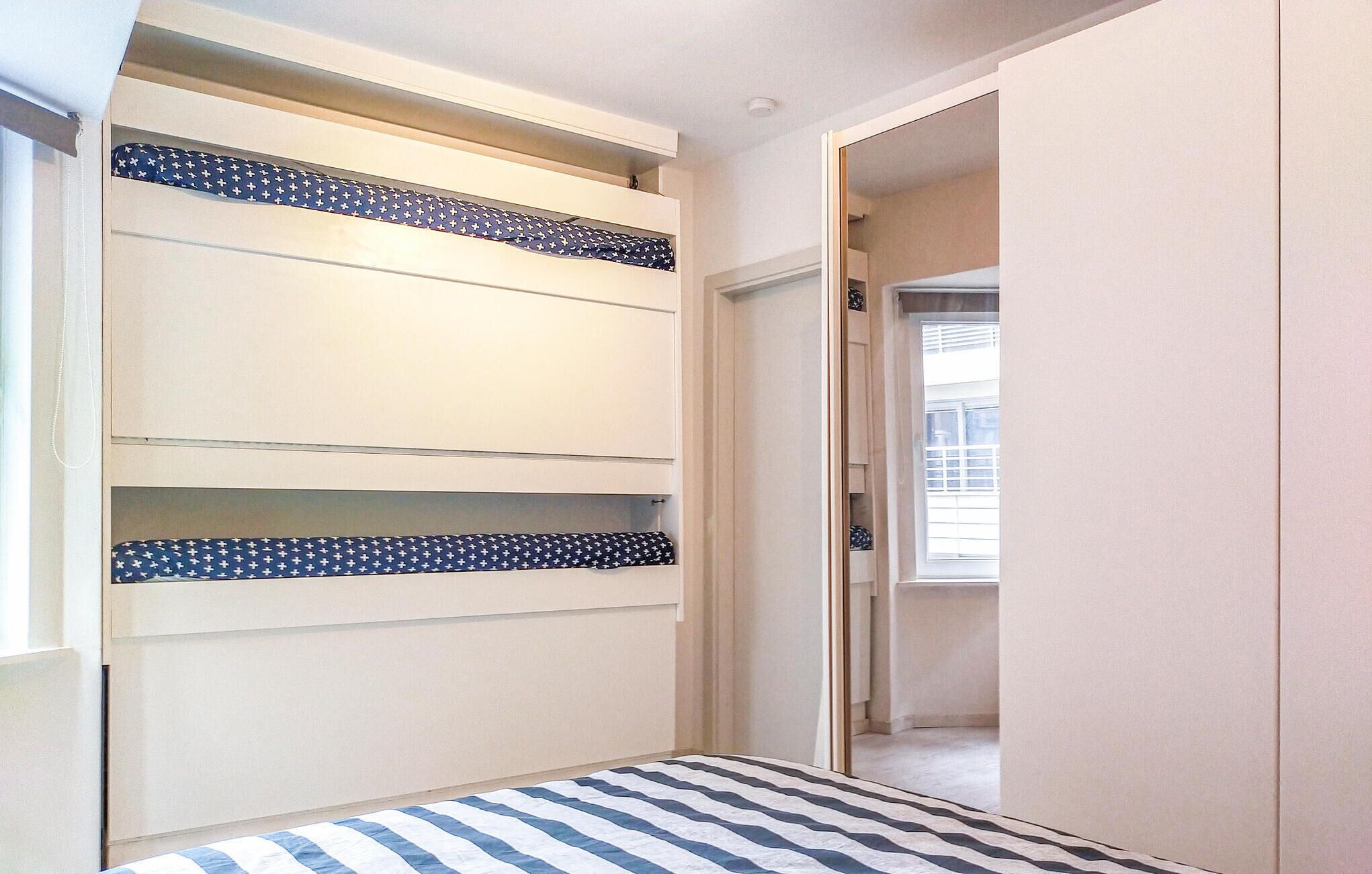Un couloir étroit avec un lit au fond.