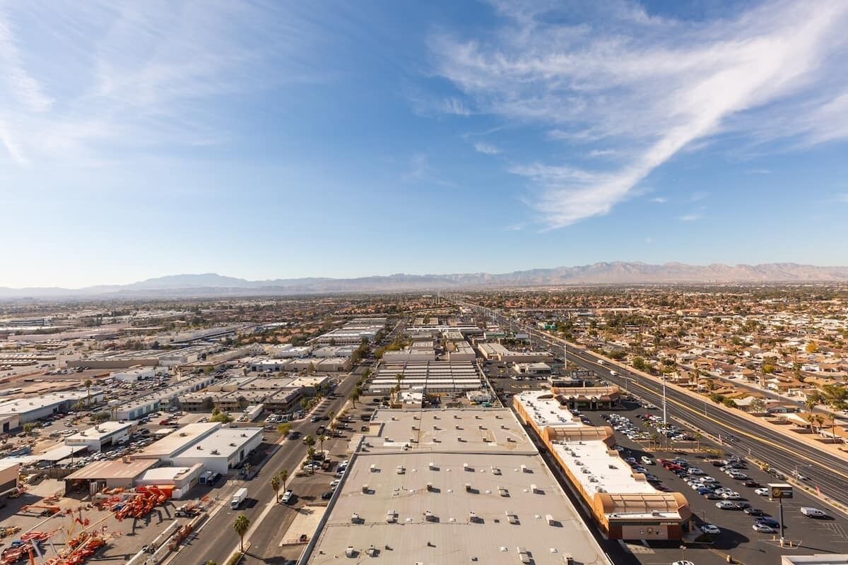 An aerial view of a commercial area with multiple buildings, roads, and a parking lot.