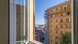 A view from a window overlooking a building with yellow shutters and a scaffolding structure.
