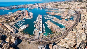 An aerial view of a coastal city with a marina, roads, and buildings.