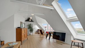 A spacious loft with high ceilings, a large skylight, and a cozy seating area with a foosball table. - Lovely home in Vestervig with sauna (Vestervig)
