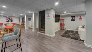Ein geräumiger Wohnbereich mit Esstisch, Stühlen, einer Treppe und einem 'Parkverbot'-Schild an der Wand.