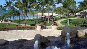A resort with a pool, palm trees, and a view of the ocean. - Deluxe Ocean View Studio Marriott Ko Olina Beach Club!  6/25/2027 - 7/2/2027. (Kapolei)