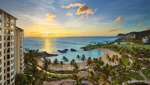 A resort with a pool, palm trees, and a view of the ocean at sunset. - Deluxe Ocean View Studio Marriott Ko Olina Beach Club!  6/25/2027 - 7/2/2027. (Kapolei)