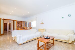 Un salon comprenant un canapé, une table en bois et un coin repas avec des chaises.