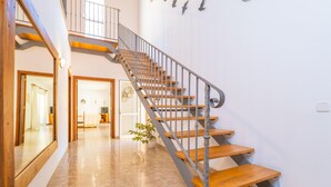 Una escalera con escalones de madera y barandales de metal que conduce a un piso superior.