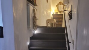 A staircase with a handrail, a radiator, and a small table with a lamp. - The traveler's choice (Genova)